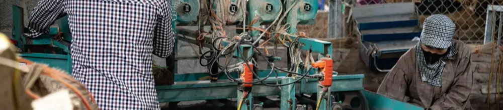 Trabalhadores operando maquinário em linha de produção industrial